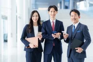 スマホ手にする3人の職員